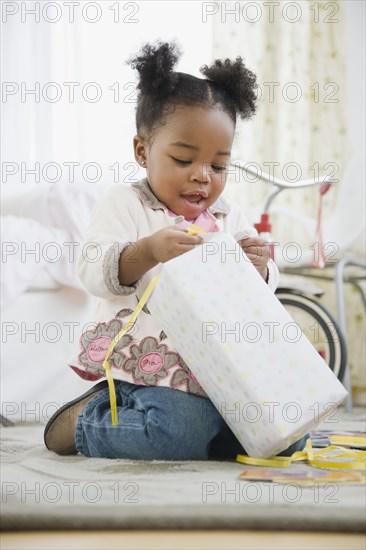 African American girl opening birthday gift