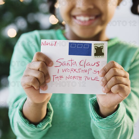 African American girl holding letter to Santa Claus