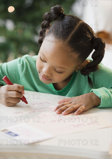 African American girl writing letter to Santa Claus