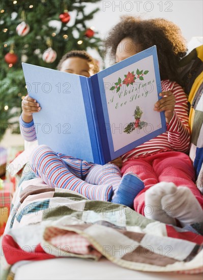 African American brother and sister reading Christmas book