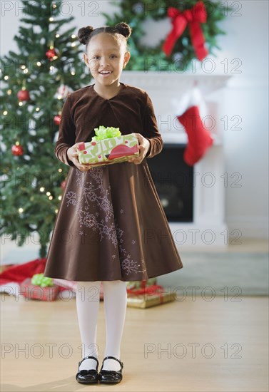 African American girl in dress holding Christmas gift