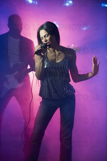 Mixed race woman singing at nightclub