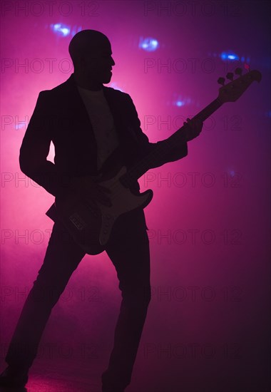 African American man playing guitar at nightclub