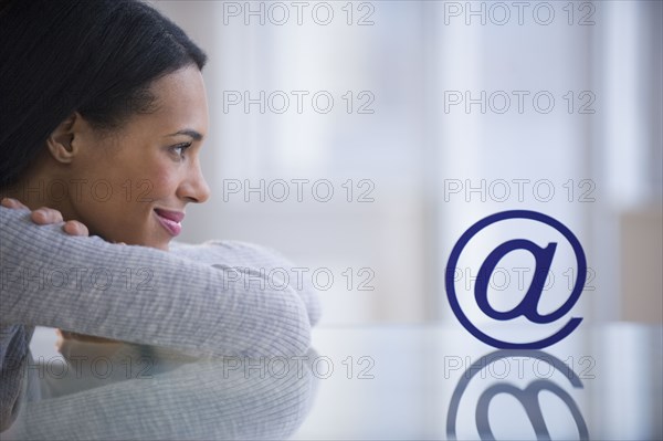 Mixed race woman staring at email symbol