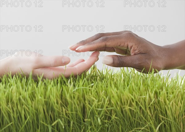 African and Caucasian woman about to hold hands