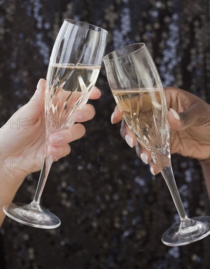 African and Caucasian woman toasting with champagne