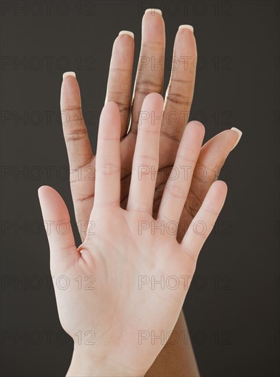 African and Caucasian woman holding hands