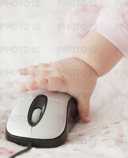 Mixed race baby girl using computer mouse