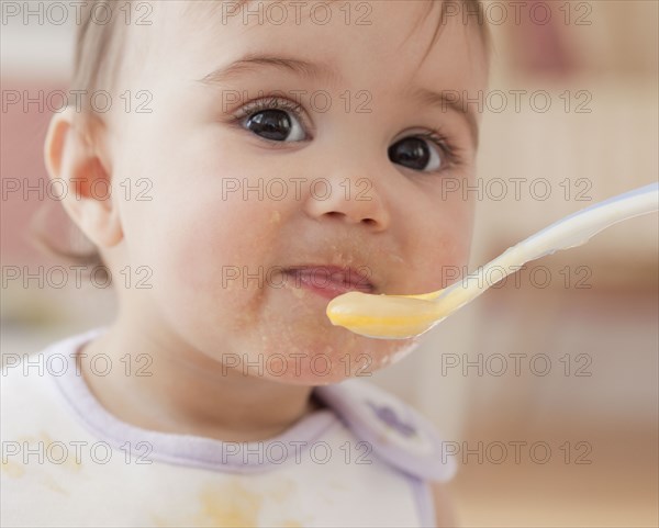 Mixed race baby girl eating