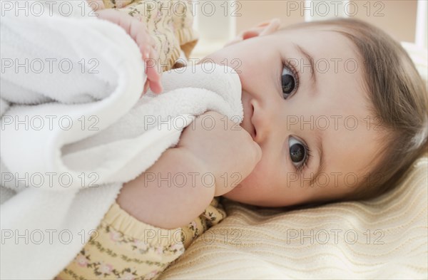 Mixed race baby girl laying in crib