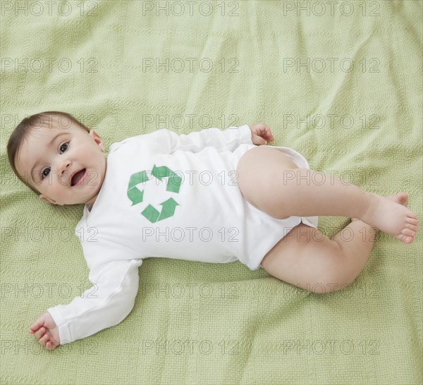 Mixed race baby girl with recycling symbol on shirt