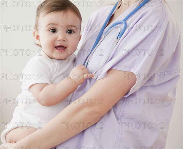 Nurse holding mixed race baby girl