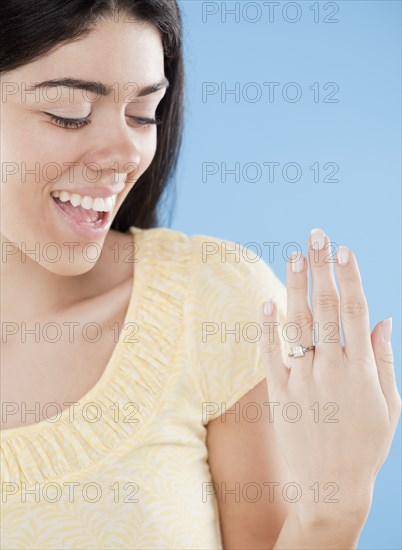 Hispanic woman displaying engagement ring