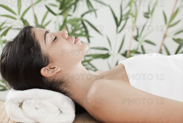 Hispanic woman laying in spa