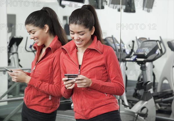 Hispanic woman text messaging in healthy club