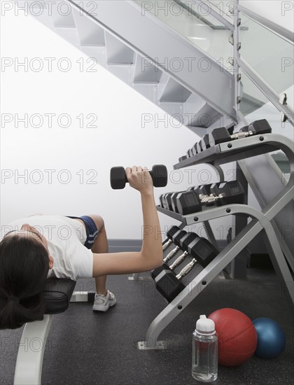 Hispanic woman using hand weights in health club