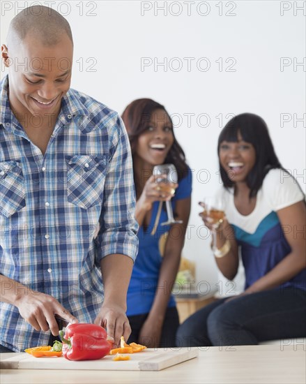 African man preparing dinner for friends