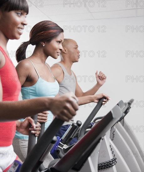 African people using exercise equipment in health club