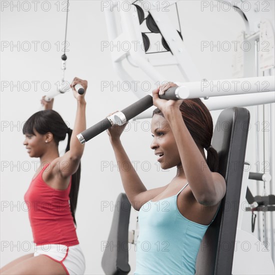 African woman using weight machines in health club