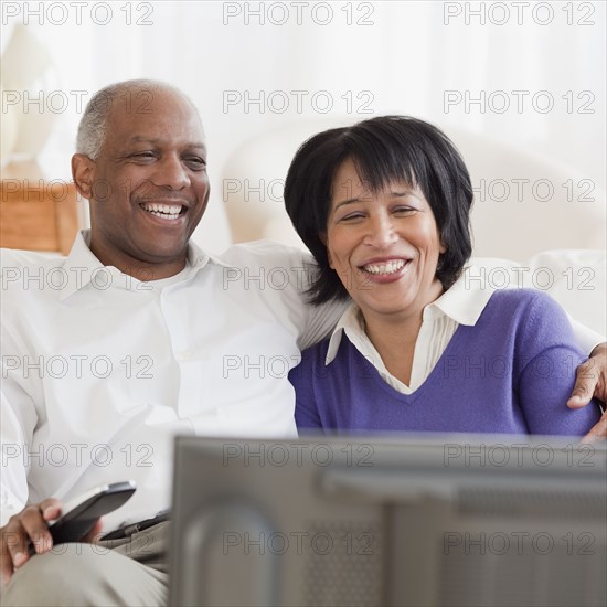 African couple watching television