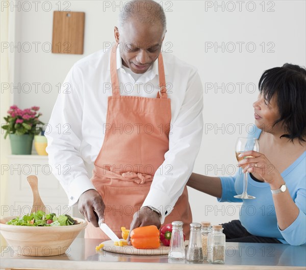 African man preparing dinner for wife