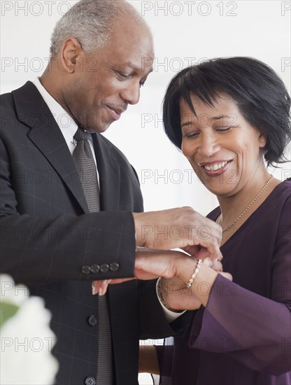 African man attaching bracelet for wife