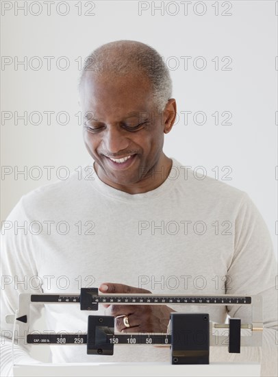 African man weighing himself