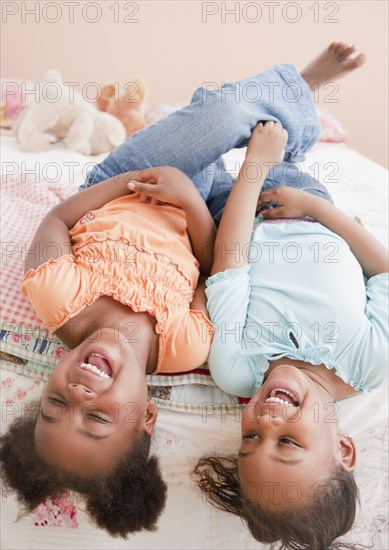 African girls laughing on bed