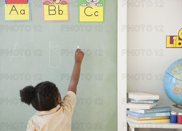 African girl writing on blackboard