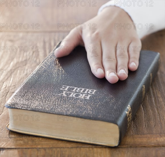 Woman's hand on Bible