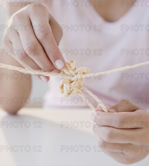 Woman tying knot in rope