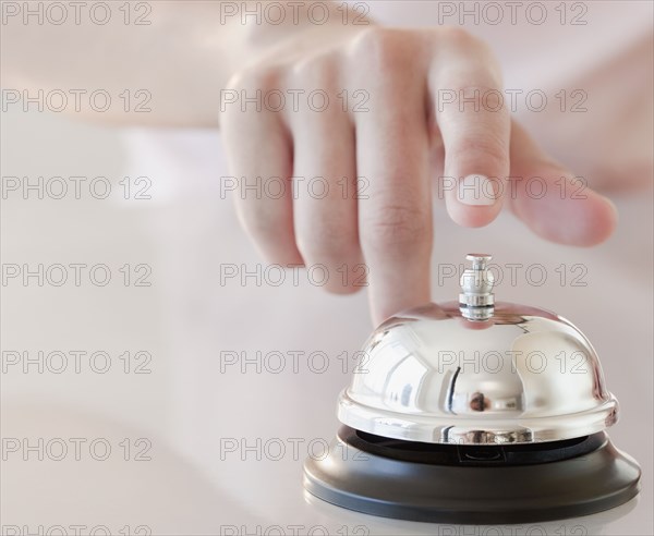 Woman tapping hotel service bell