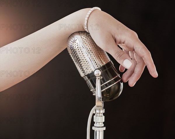 Woman's hand on retro microphone