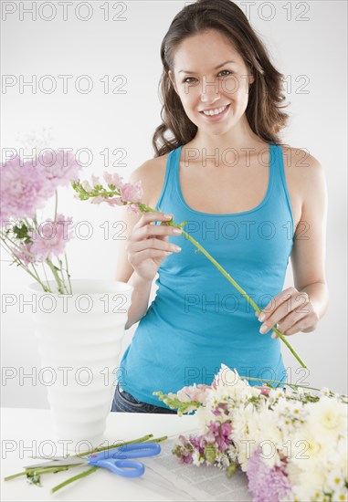 Mixed race woman arranging flowers