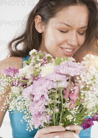 Mixed race woman holding bouquet of flowers