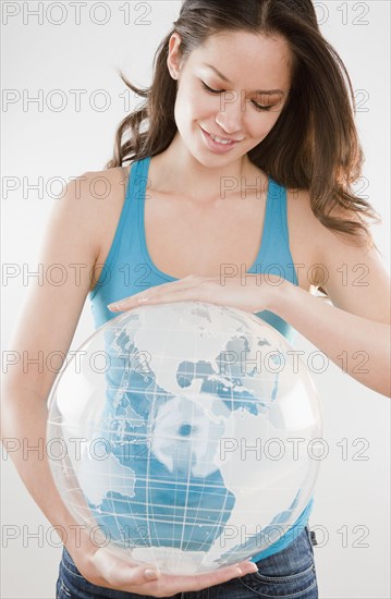 Mixed race woman holding inflatable globe