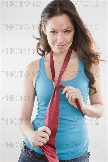 Mixed race woman wearing tie