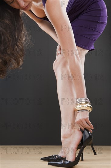 Mixed race woman putting on high heel