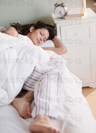 Mixed race woman sleeping in bed