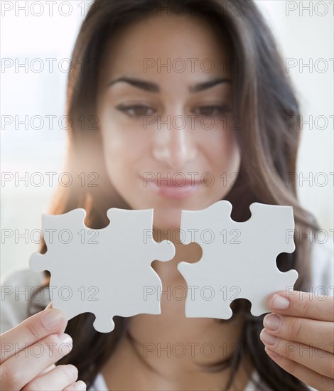 Hispanic woman holding two puzzle pieces