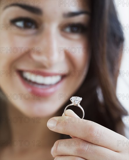 Hispanic woman holding engagement ring