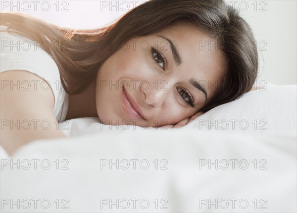 Hispanic woman laying on bed