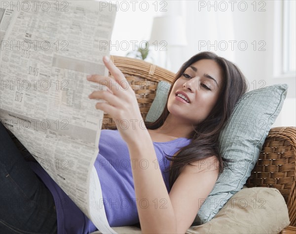 Hispanic woman reading newspaper