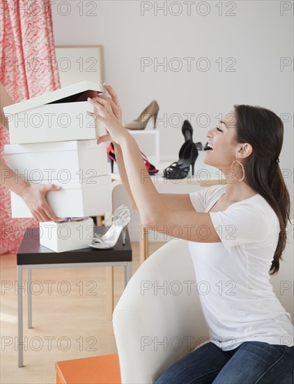 Hispanic woman eyeing shoe boxes at store