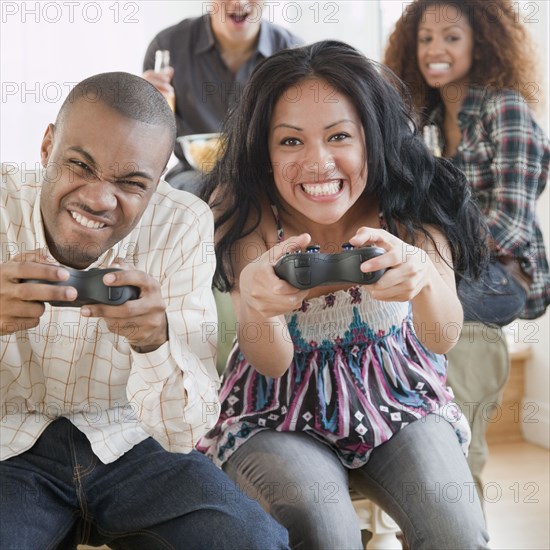 Man and woman playing video game and making faces