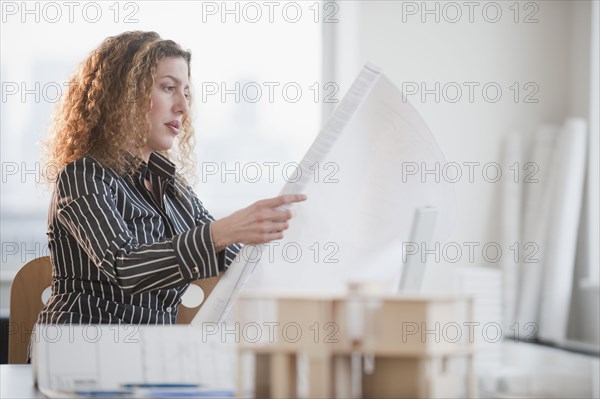 Hispanic woman looking at blueprints