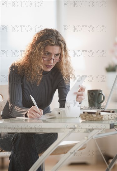 Hispanic woman paying bills