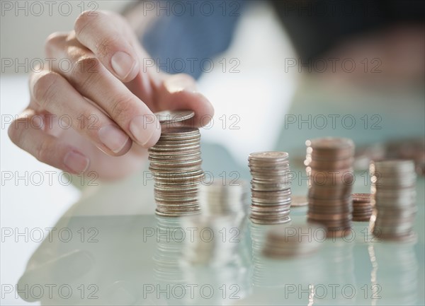 Close up of Hispanic woman stacking coins