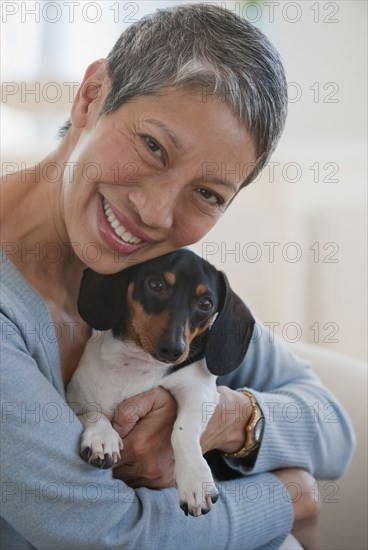 Chinese woman holding dachshund