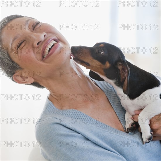 Dachshund licking Chinese woman's face